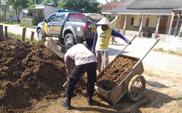 Polisi Bantu Pengurugan di Bahu Jalan Desa Sabajaya