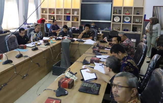 Bandung, sekilasjabar.co – Panitia Khusus yang membahas Rancangan Peraturan Daerah tentang Pembudayaan Ideologi Pancasila dan Wawasan Kebangsaan memulai rapat perdananya, di Ruang Komisi C, Jumat, 8 November 2024. Raperda baru ini merupakan salah satu dari lima usulan wali kota Bandung yang baru ditetapkan di rapat paripurna, Rabu, 6 November 2024 lalu. Rapat ini diisi Ketua Pansus 2, AA Abdul Rozak, S.Pd.I., M.Ag., Wakil Ketua Pansus 2, Erick Darmadjaya, B.Sc. M.K.P., serta para Anggota Pansus 2, Agus Hermawan, S.A.P., dan Iqbal Mohamad Usman. S.IP. Dari Pemerintah Kota Bandung, hadir Kepala Bidang Ideologi Wawasan Kebangsaan di Badan Kesatuan Bangsa dan Politik (Kesbangpol) Kota Bandung Aswin Sulaeman beserta jajarannya. Dalam pemaparannya, Tim Naskah Akademik Kesbangpol Kota Bandung mengungkap tujuan dari Raperda ini yakni untuk mengakarkan ideologi Pancasila di tengah kehidupan bermasyarakat Kota Bandung. Raperda ini akan menjadi payung hukum di kota dan kabupaten setelah dua tahun terakhir pemerintah pusat gencar menyosialisasikan pembudayaan ideologi Pancasila. Penciptaan Raperda ini merujuk pada terjadinya pergeseran pemahaman dan implementasi nilai-nilai Pancasila tentang kehidupan berbangsa dan bernegara. Pancasila tidak lagi menjadi pedoman dan acuan dalam interaksi kehdupan berbangsa dan bernegara. Dampak globalisasi serta perkembangan teknologi informasi turut mendorong berkembangnya berbagai sistem nilai yang tidak sejalan dengan nilai-nilai Pancasila. Lalu, Raperda ini dipengaruhi pula oleh munculnya ideologi baru yang berasal dari luar yang telah membawa sistem dan struktur sosial serta politik serta terdegradasinya jati diri dan identitas Indonesia. Selain itu, terdapat kuatnya infiltrasi dan hegemoni kelompok-kelompok yang menyimpang dari nilai-nilai Pancasila, yang berdampak terhadap kebijakan sosial dan politik yang menjadi penyebab lemahnya aktualisasi nilai-nilai Pancasila dalam setiap aspek kehidupan. Harapannya, dengan adanya Raperda ini akan membentuk karakter dan jati diri SDM Indonesia, terutama Kota Bandung, agar tetap memegang teguh nilai Panacasila sesuai dengan jati diri Kota Bandung yang ramah, toleran, dan berbudaya yang mendunia. Selain itu, Raperda ini mengarahkan pada terciptanya keharmonisan dan kerukunan, serta meningkatkan kuailtas pemahaman masyarakat tentang Pancasila dan karakter bangsa. Nantinya, proses pembahasan dan sosialisasi penerapan Raperda tentang Pembudayaan Ideologi Pancasila dan Wawasan Kebangsaan ini akan mengikutsertakan peran serta masyarakat, kerja sama bersama organisasi kepemudaan, instansi/lembaga vertikal, pemerintah daerah, perguruan tinggi, masyarakat, partai politik, organisasi kemsyarakatan, dunia usaha, dan media massa. Adapun objek sasaran pembudayaan ini yakni siswa, mahasiswa, guru, pendidik, organisasi politik, organisasi kemasyarakatan/Lembaga nirlaba lainnya, apparatur sipil negara, tokoh agama/masyarakat/adat, pendidikan formal dan inoformal. Wakil Ketua Pansus Raperda tentang Pembudayaan Ideologi Pancasila dan Wawasan Kebangsaan, Erick Darmadjaya mengatakan, materi yang dihadirkan akan menambah banyak wawasan untuk manfaat di masa mendatang. Ia berharap implementasinya nanti mampu menyesuaikan dengan kondisi, situasi, dan tren masyarakat sehingga mudah dipahami dan diterapkan. “Jadi dengan adanya Raperda ini penyelenggara negara punya payung hukum. Perda itu tiang-tiang sebelum peraturan teknis. Jadi jangan hanya sekadar teoritis. Meski teknis nanti di Peraturan Wali Kota, tetapi sejak awal di Perda perlu dicantumkan program yang sifatnya aplikatif,” tutur Erick. Anggota Pansus, Agus Hermawan menegaskan bahwa Raperda ini wajib dimiliki Kota Bandung untuk menguatkan identitas warga sebagai bangsa Indonesia. “Kalau berbicara iedologi, ini harga mati. Ini karakter yang dibutuhkan bangsa Indonesia. Tentang ideologi ini sebenarnya sudah ada di UUD 45, tetapi bagamana mengimplementasikan di bawahnya sehingga mampu membentuk moral generasi bangsa Indonesia ke depan,” ujar Agus Hermawan. Oleh karena itu, ia berharap penerapan Raperda ini nantinya bisa dengan mudah diterima masyarakat, termasuk anak-anak dan remaja. “Cari formulasi implementasinya. Sekarang budaya impelentasi, bagaimana anak kecil bisa senang, ada video, perlombaan, sehingga menjiwai rasa nasionalis kebangsaan ini. Nanti kita cari studi banding kepada para pakar,” tuturnya. Anggota Pansus, Iqbal Mohamad Usman menjelaskan, kondisi Indonesia saat ini seolah sudah tidak sesuai lagi dengan nilai Pancasila. Terjadi asinkronisme karena banyak budaya asing yang masuk dan memengaruhi rakyat Indonesia. “Lulusan pendidikan warga rata-rata hingga SMP. Ditambah budaya literasi kurang. Dengan media sejarah penerapan Pancasila seharusnya tersampaikan dengan baik. Jangan terlalu kaku, harus bisa aplikatif supaya bisa dengan bermanfaat bagi masayarakat, termasuk menyesuaikan dengan pola-pola komunikasi generasi sekarang dan masa mendatang,” kata Iqbal. Ketua Pansus 2, AA Abdul Rozak menambahkan, harapan dari lahirnya Perda ini supaya pemerintah memiliki payung hukum untuk menerapkan nilai-nilai Pancasila dan wawasan kebangsaan. Ia pun meminta dalam proses penerapannya nanti sepatutnya mengikuti konsep yang seiring zaman. Apalagi jika penerapannya di Kota Bandung yang dihuni ragam latar belakang warganya. “Kota Bandung ini urban, perkotaan, isinya berbeda-beda. Perda ini nantinya bisa menjadi pemersatu masyarakat yang mengisi kehidupan di Kota Bandung. Literasi sekarang kurang, minat baca kurang. Bisa dibuat film tentang kebinekaan, toleransi, kebangsaan. Intinya kami dari pansus menyampaikan terima kasih kepada Kesbangpol. Buatlah program yang simpel, aplikatif, dan mengena. Mari ke depan sama-sama menjaga NKRI dan Kota Bandung, minimal Raperda ini menjadi pilot project untuk wilayah di Jawa Barat,” ujarnya.***